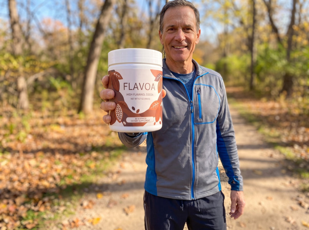 Smiling man on a walking trail holding up a jar of Flavoa
