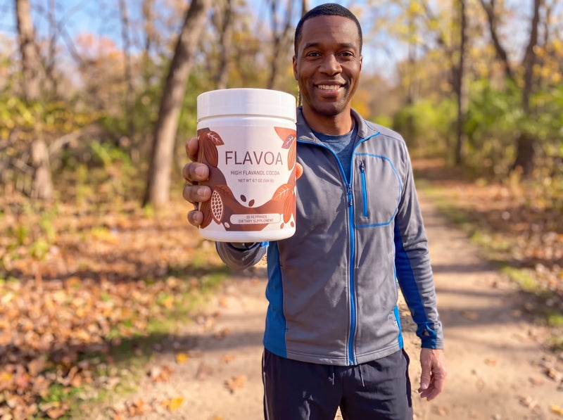 Smiling man on a walking trail holding up a jar of Flavoa