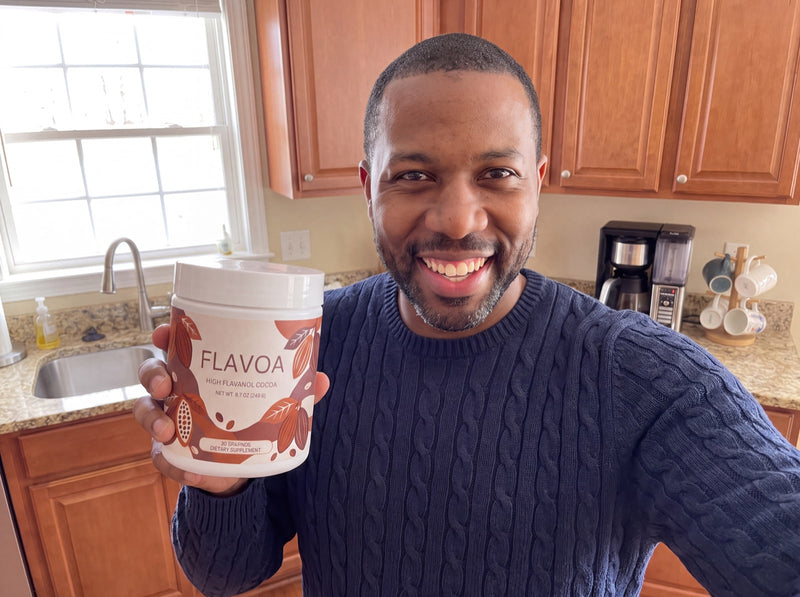 Reviewer holding his jar of Flavoa high flavanol cocoa in the kitchen
